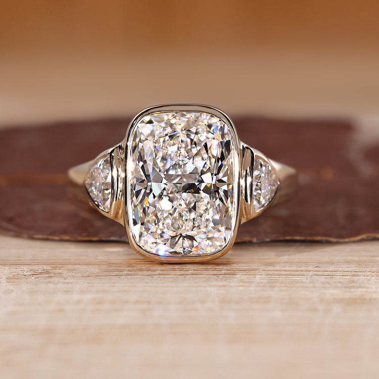 Cushion cut diamond ring with trillion side stones.