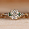 Cushion cut diamond ring with marquise green emerald side stone.