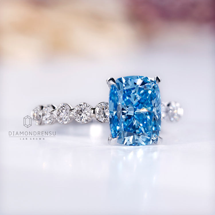 IGI certified blue diamond ring with shared pave setting.