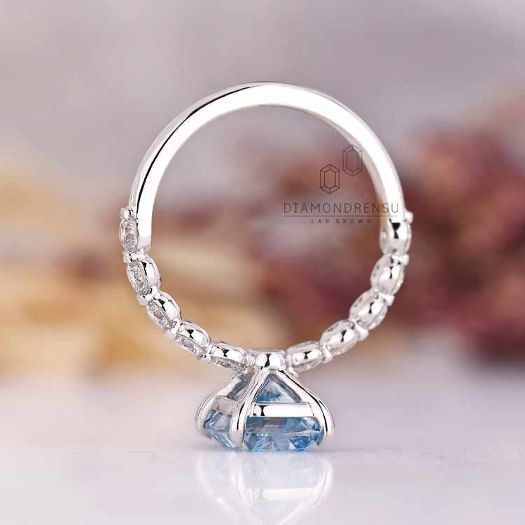 Handmade blue diamond ring with shared pave band.