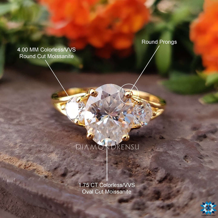 Moissanite engagement ring with oval and round cut stones.
