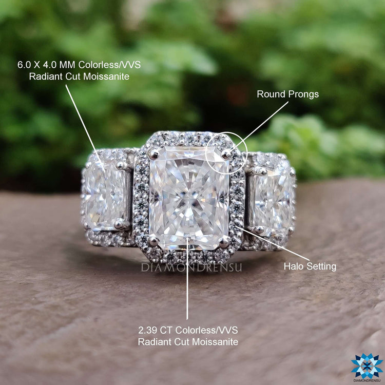 Radiant cut moissanite ring with round side stones in white gold.
