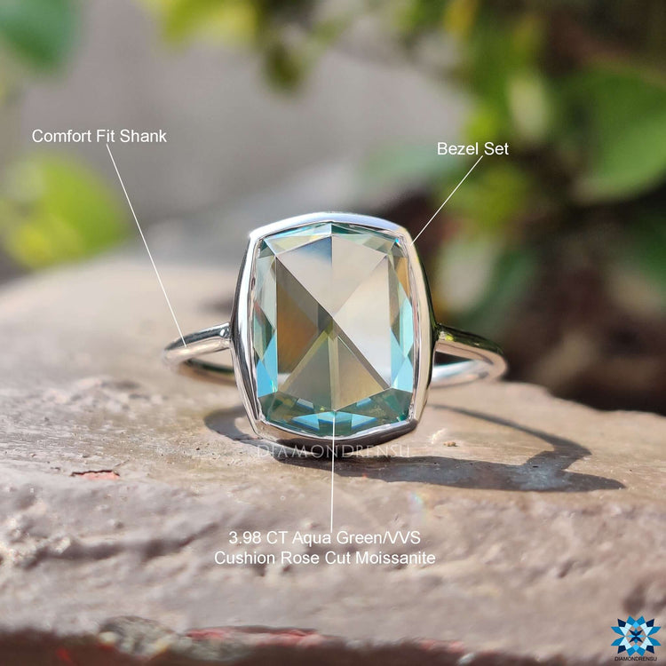 White gold engagement ring with bezel set cyan blue moissanite.
