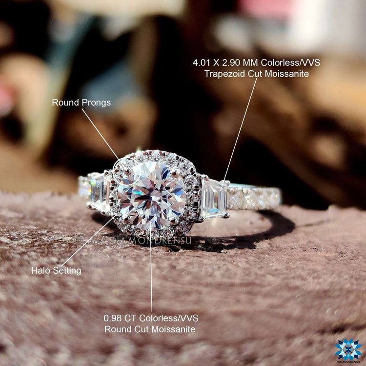 White gold halo engagement ring with trapezoid side stones and filigree elements.

