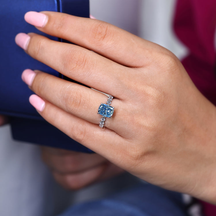 Lab grown blue cushion diamond ring with pave band.