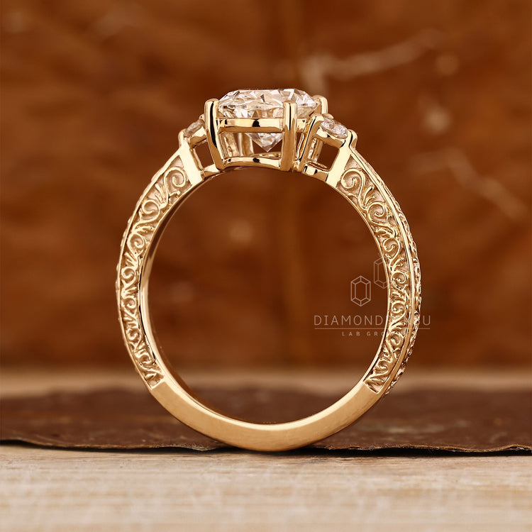 Oval diamond engagement ring with vintage style filigree shank.
