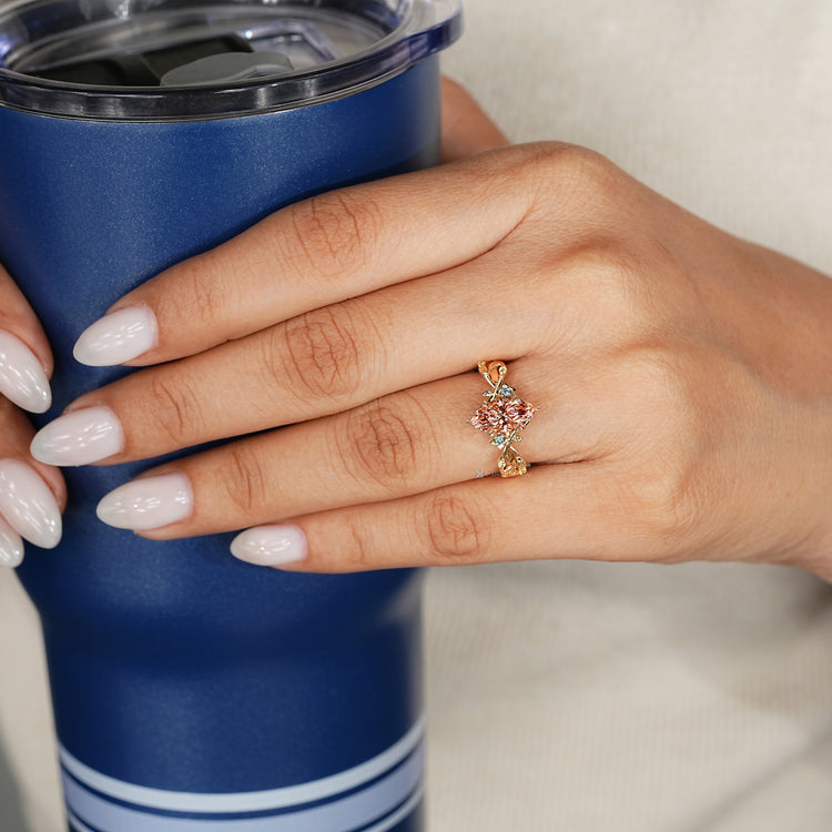 Pink marquise diamond ring with peridot side stones.