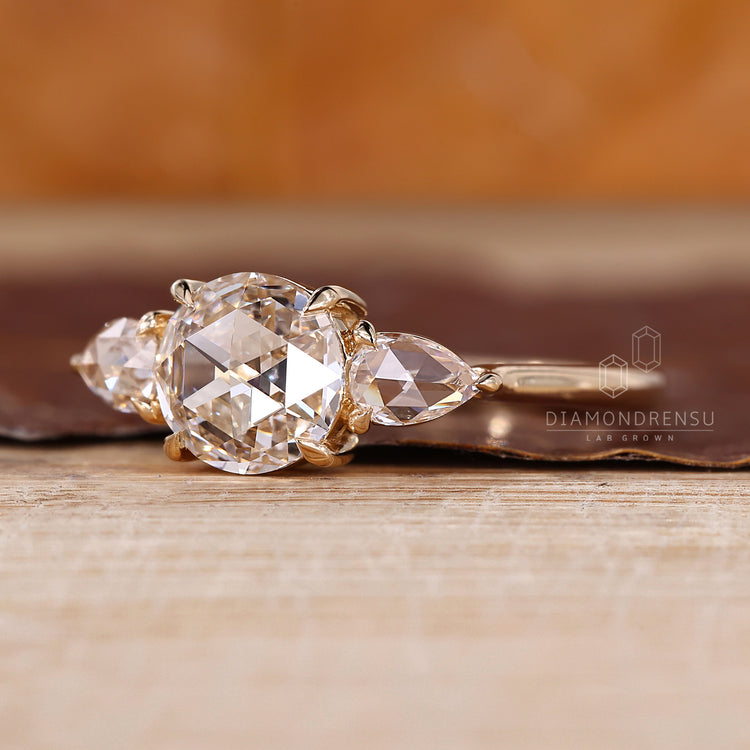Round rose cut diamond ring with pear side accents.