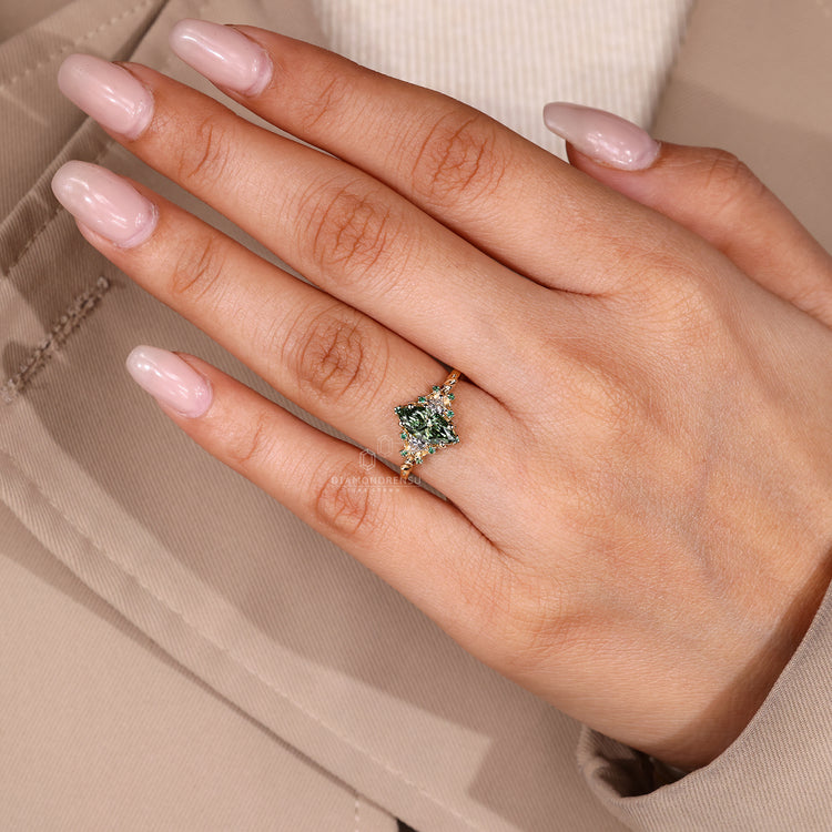 Marquise diamond ring with green round side stones.