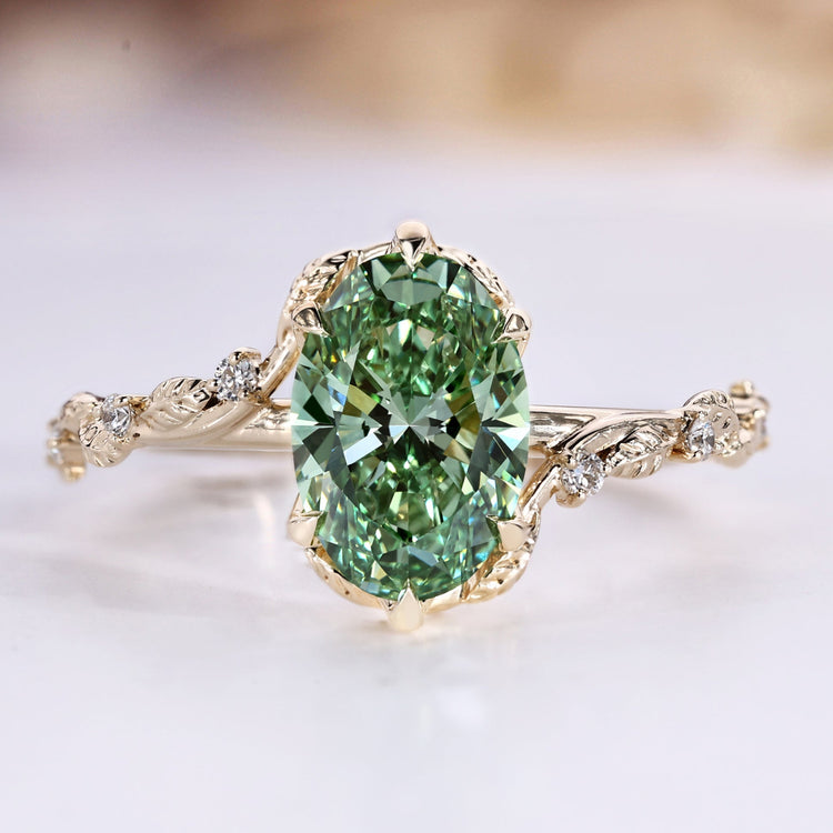 Oval cut ring with green centre diamond and round side stones.
