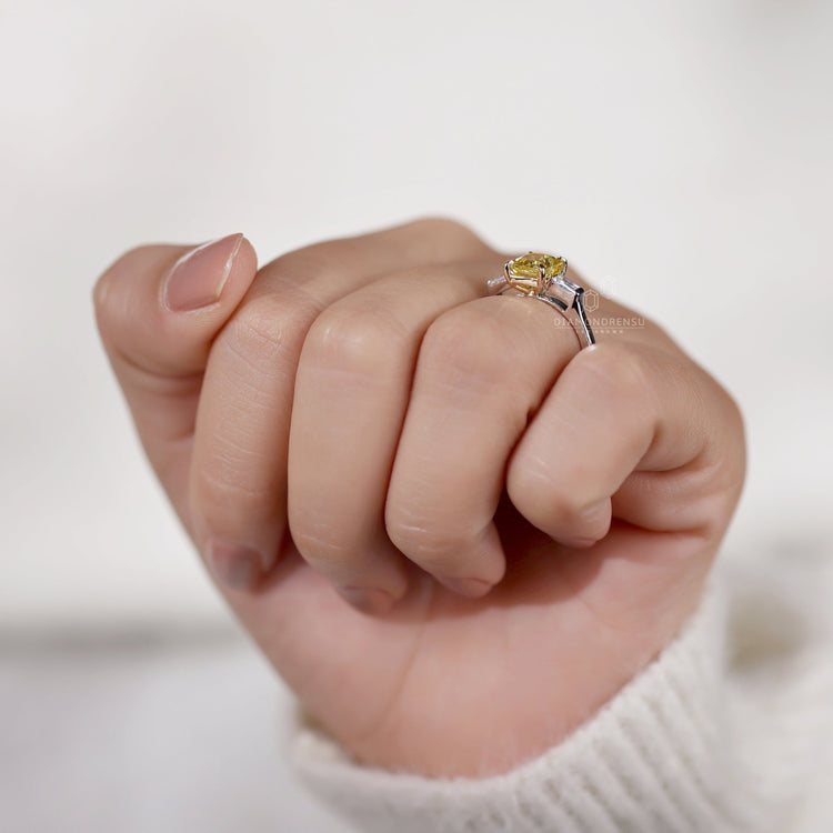 Radiant cut ring with a baguette cut diamond and claw prong setting.