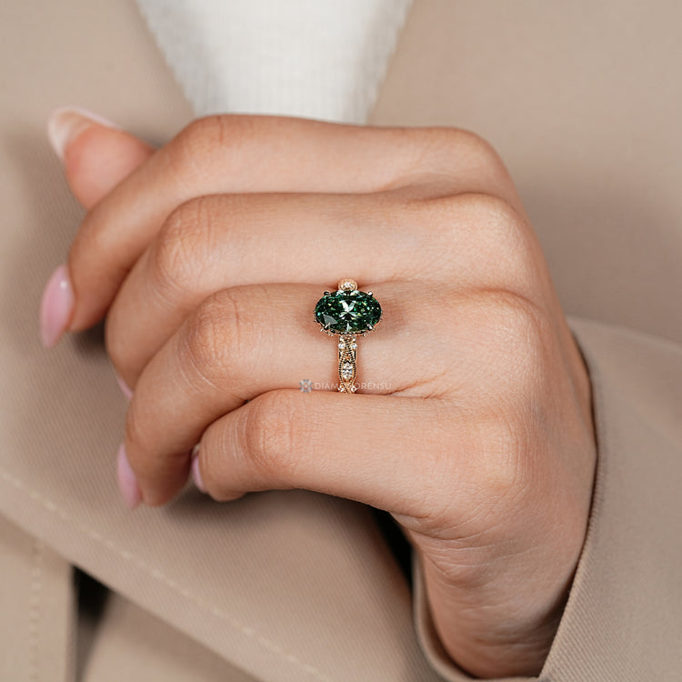 Green centre diamond ring with four claw prong setting.