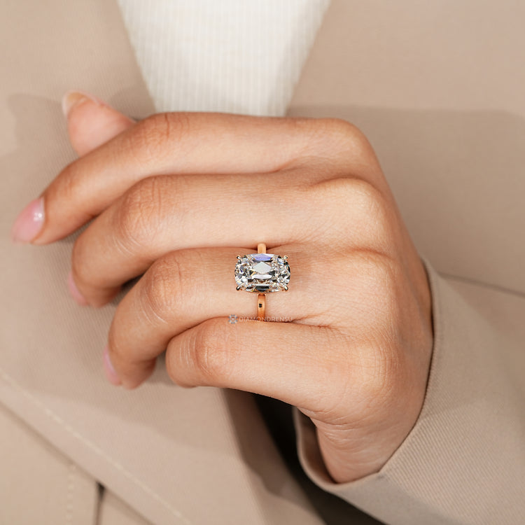 Cushion OMC solitaire ring with four claw prongs.