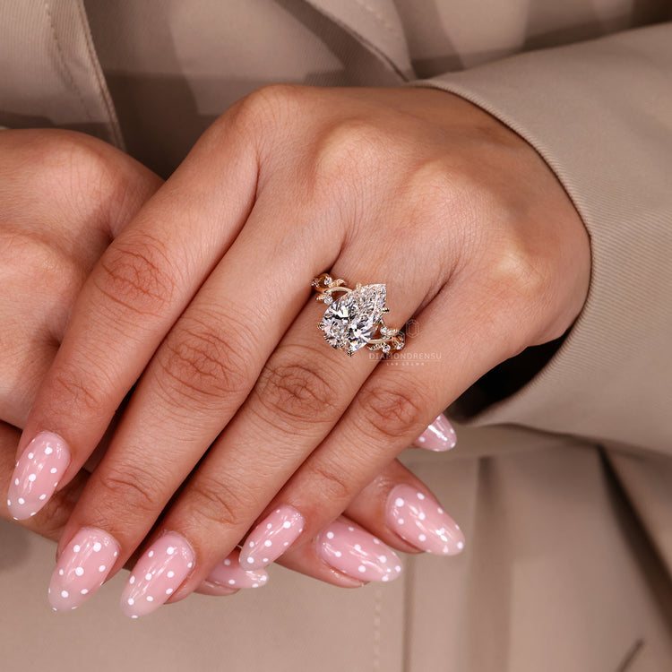 Leaf detail diamond ring with pear cut centre stone.