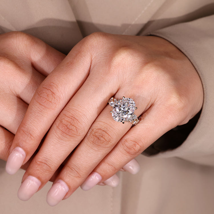 Oval engagement ring with marquise and round accents.