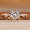 Pave engagement ring with heart cut diamond and round side stone.