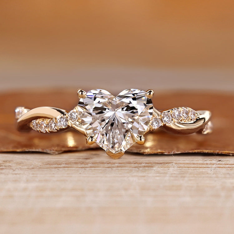 Pave engagement ring with heart cut diamond and round side stone.