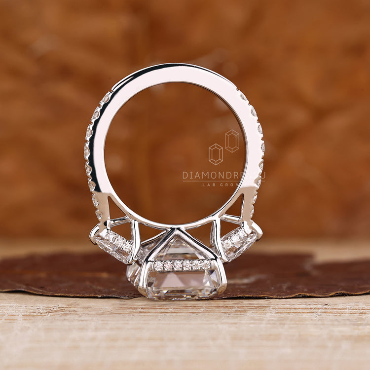 Three stone emerald diamond ring with open gallery view.