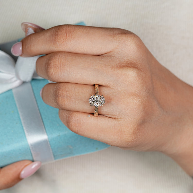 Oval diamond ring with floral engraved shank.