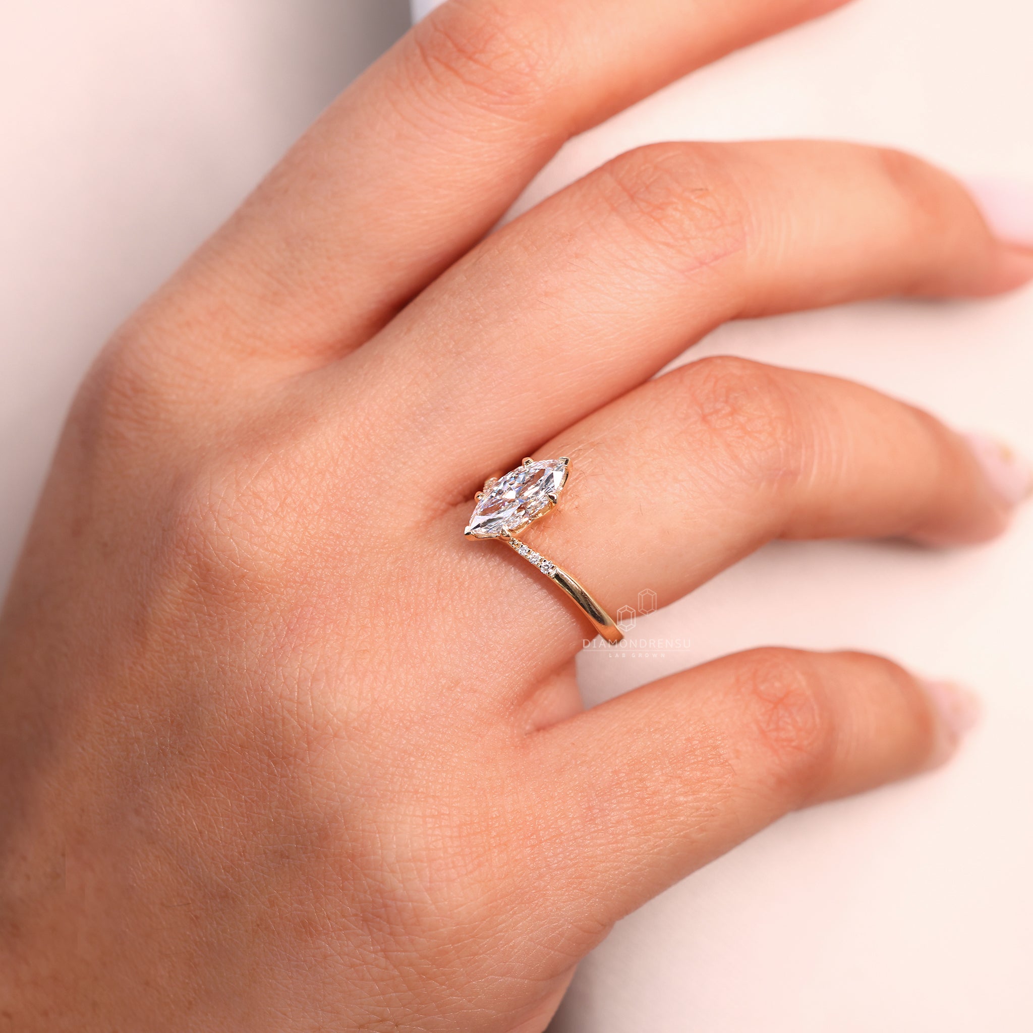 Round diamond side stone added beside marquise center diamond.
