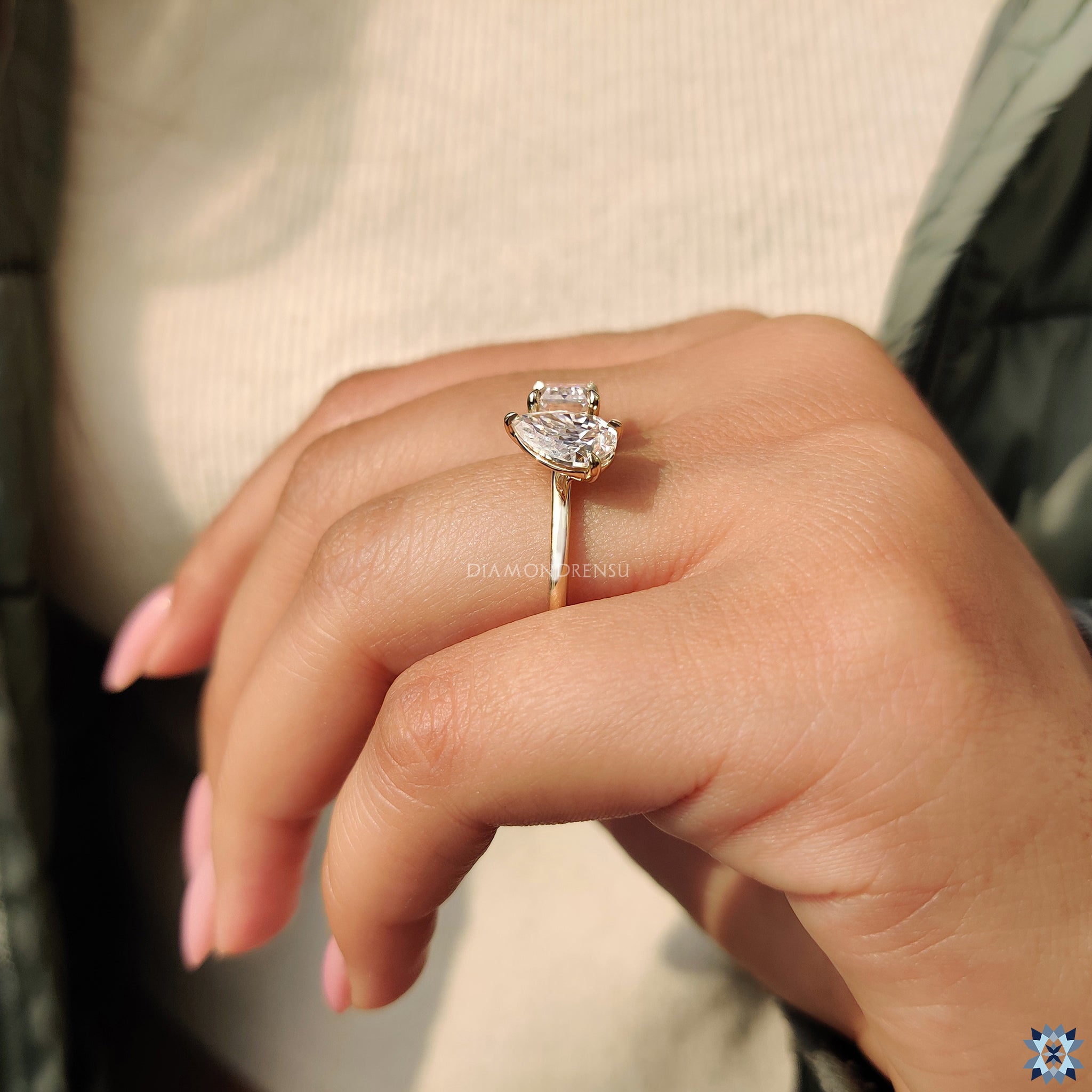 Buy moissanite ring featuring emerald and pear stones in yellow gold.
