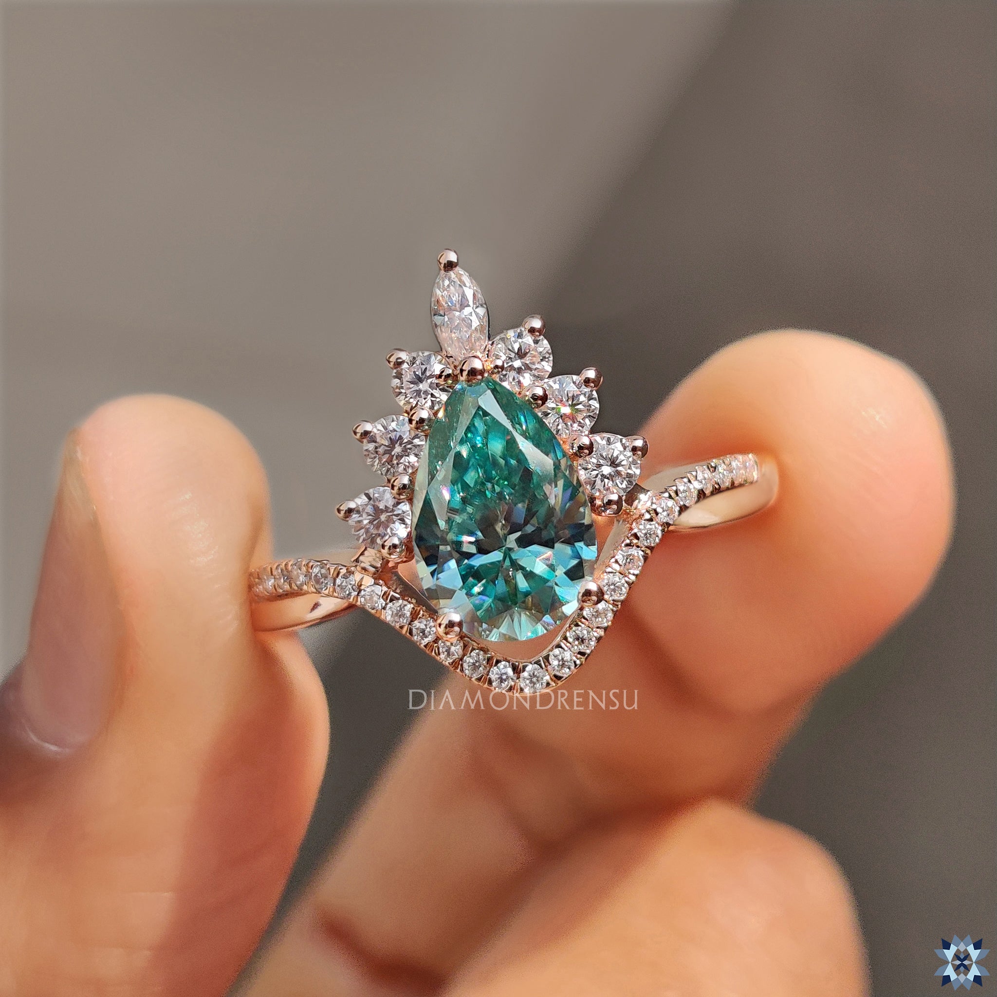 Upside down pear Moissanite in yellow gold halo ring.
