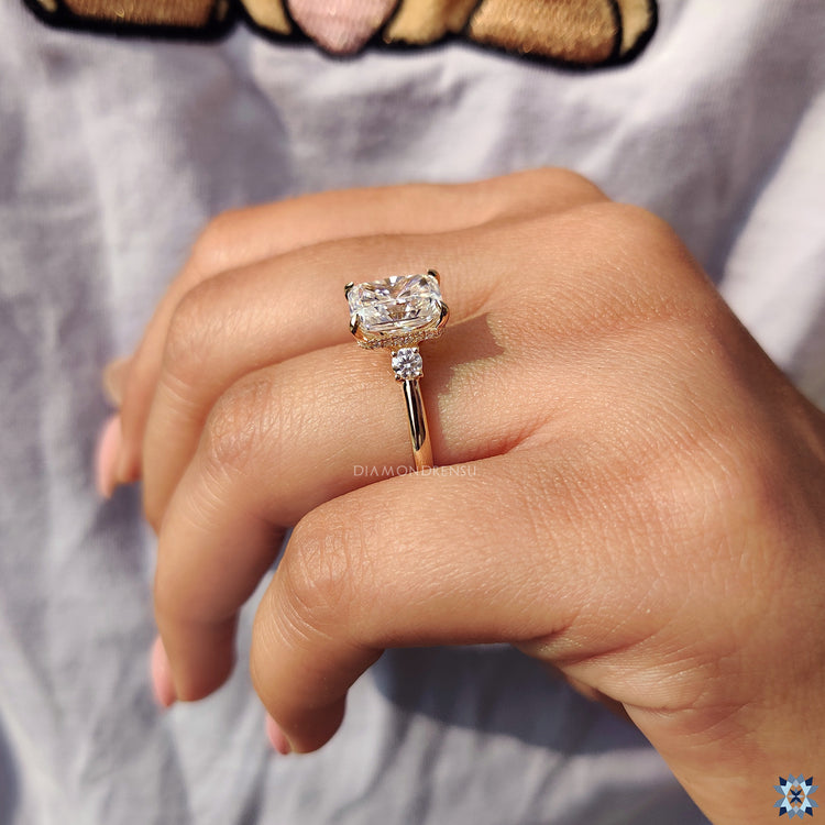 Moissanite engagement ring featuring three stone layout and claw prong setting.
