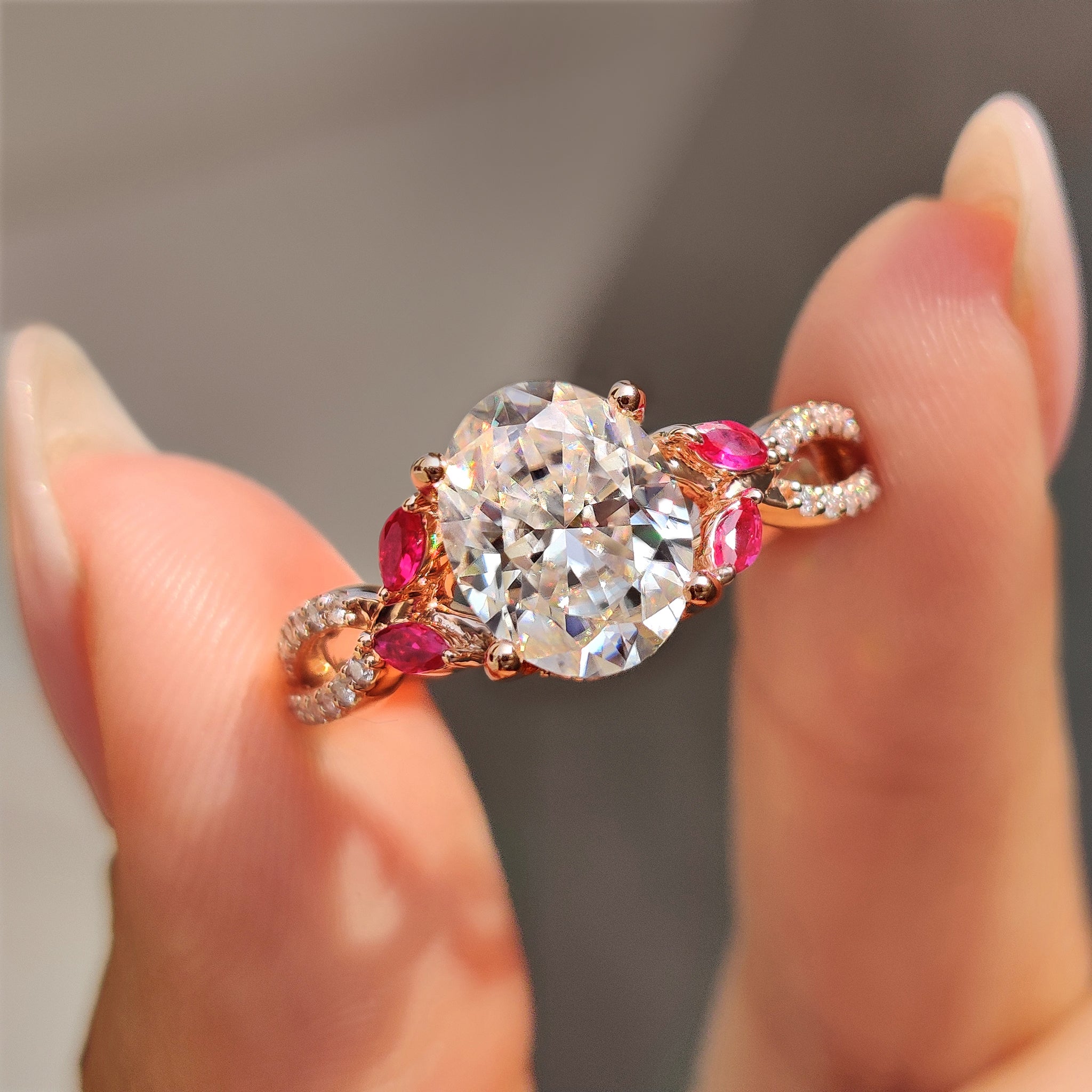 Oval engagement ring with red marquise side stones and twisted pave band.
