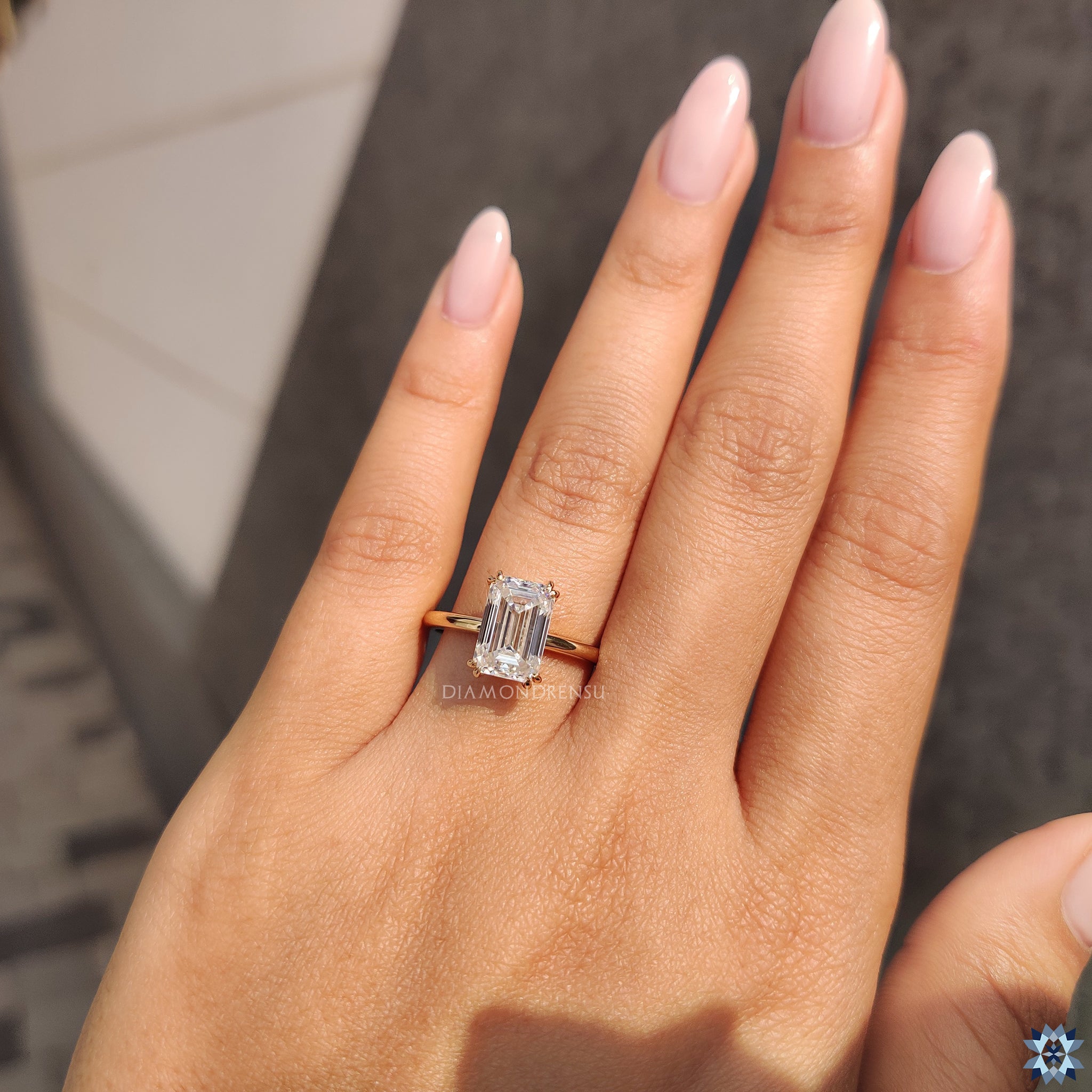 Yellow gold engagement ring with emerald moissanite in solitaire setting.
