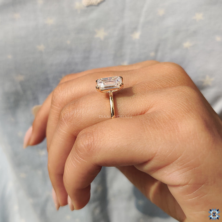 Buy moissanite ring with emerald cut in yellow gold solitaire style.
