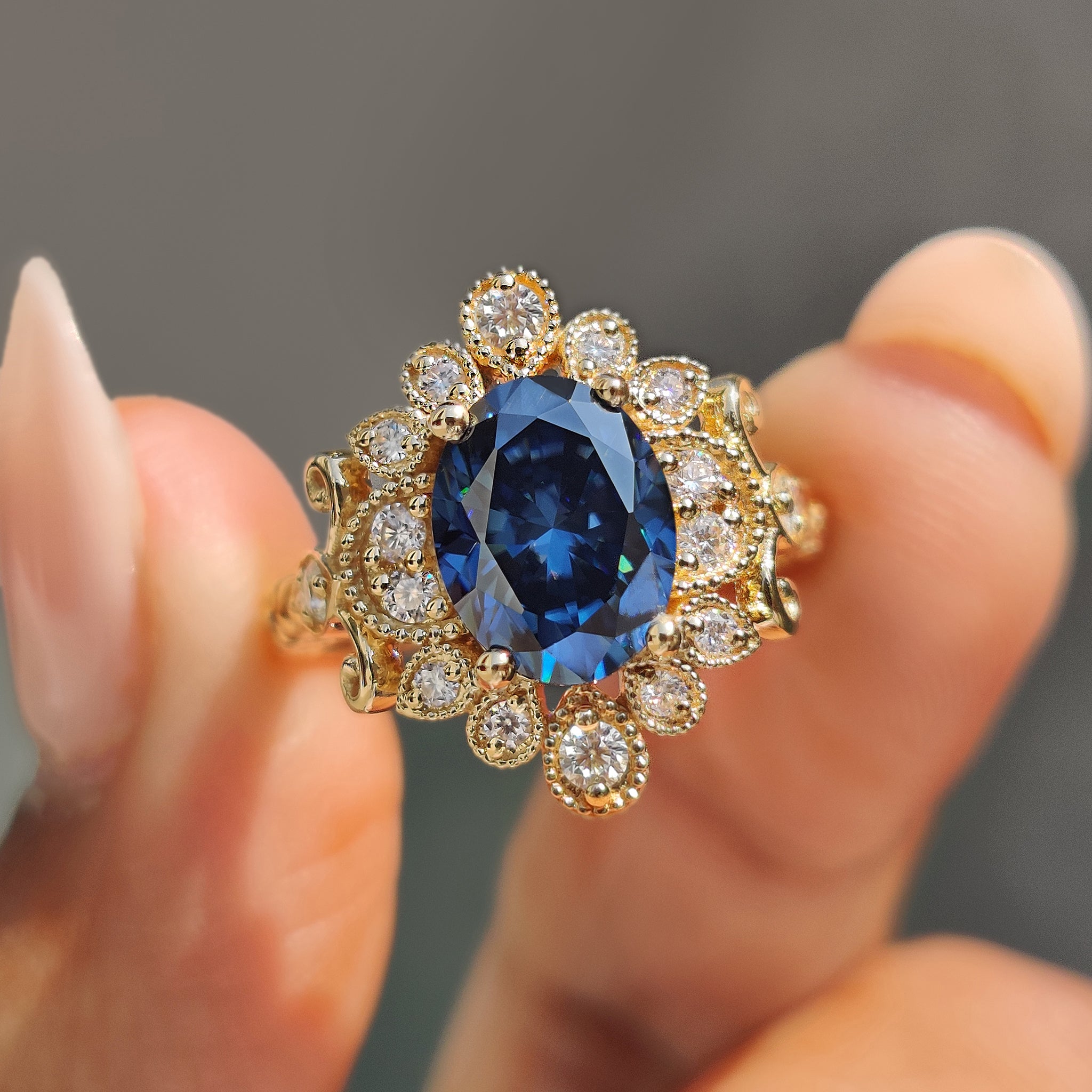 Oval moissanite engagement ring in yellow gold with milgrain detailing.
