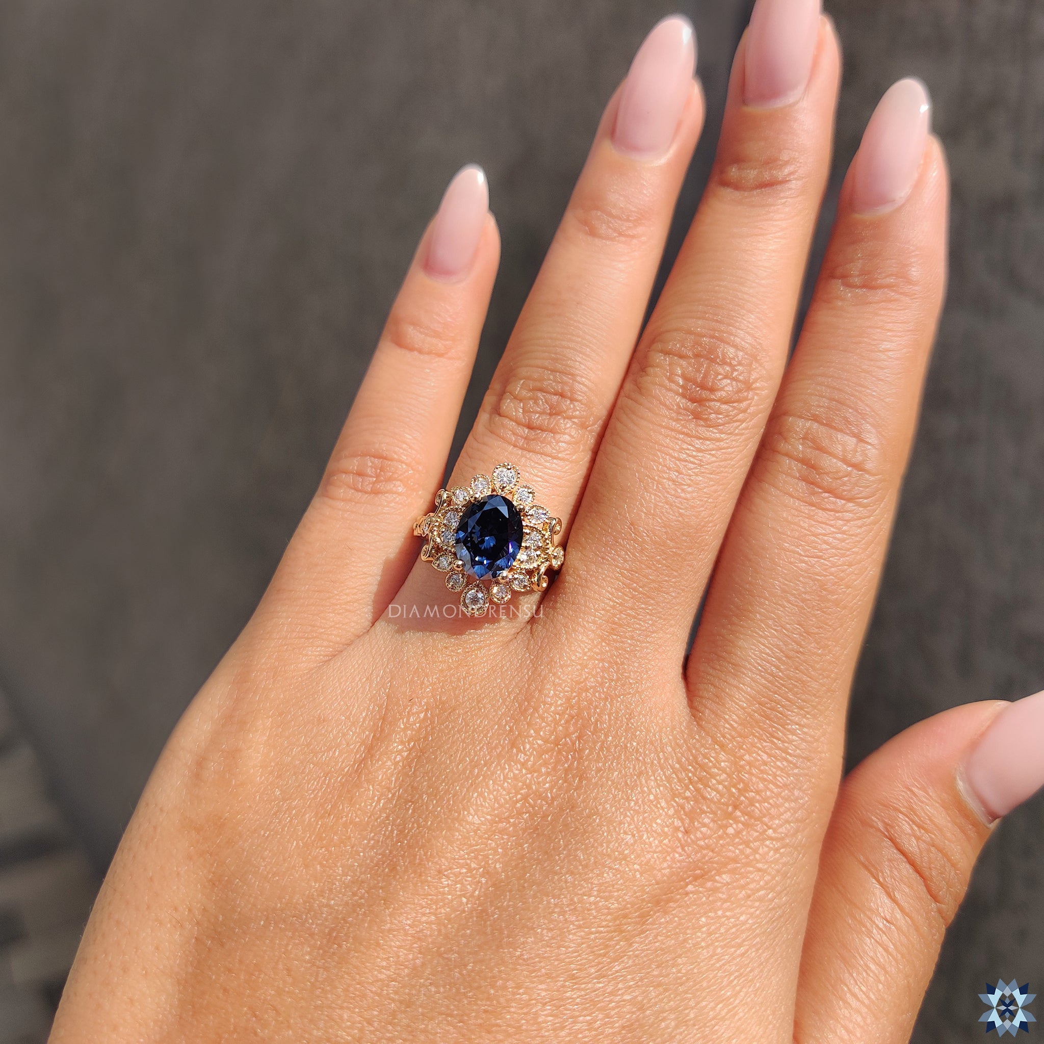 Blue oval moissanite with handmade halo engagement ring in yellow gold.
