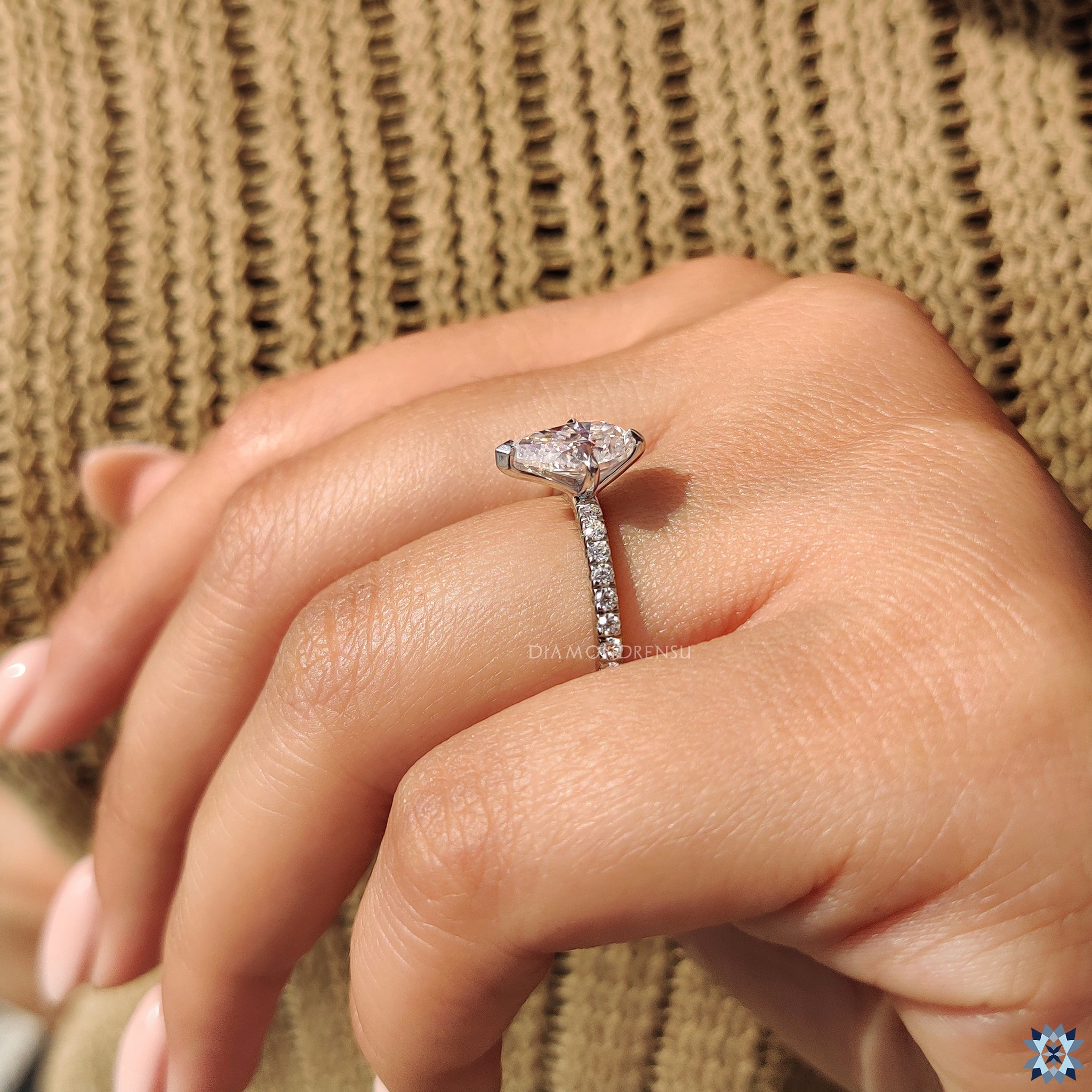 Custom engagement ring with white gold and moissanite round pave setting.
