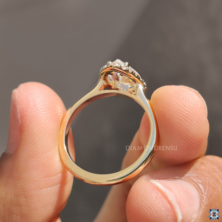 Custom engagement ring with moissanite pear shape and halo setting.
