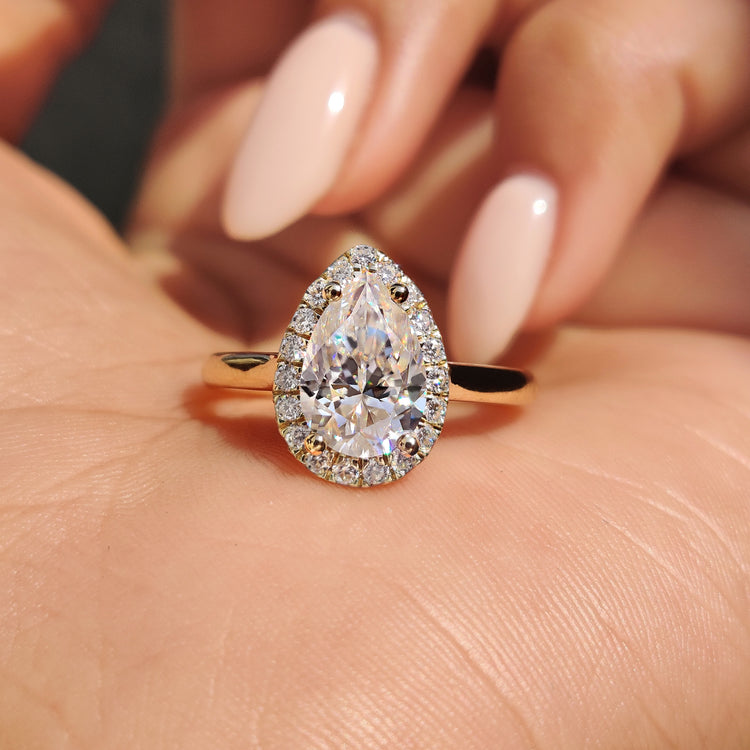 Moissanite pear ring with a 4 prong setting in yellow gold.
