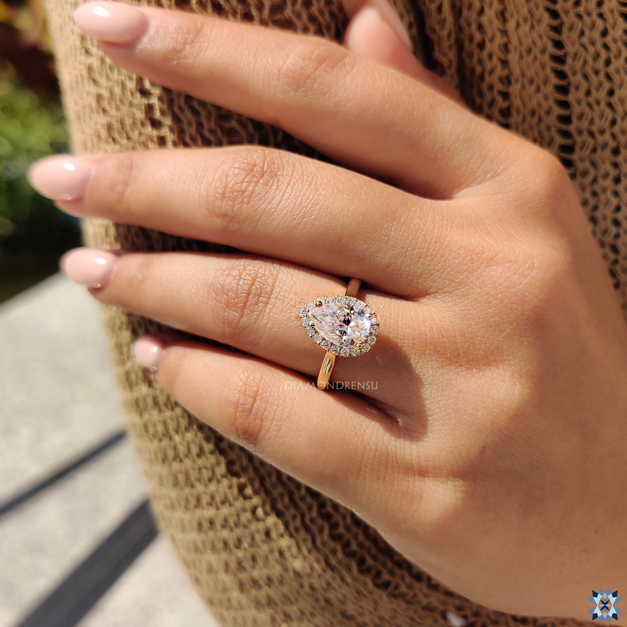 Handmade jewellery featuring moissanite pear cut in halo engagement style.
