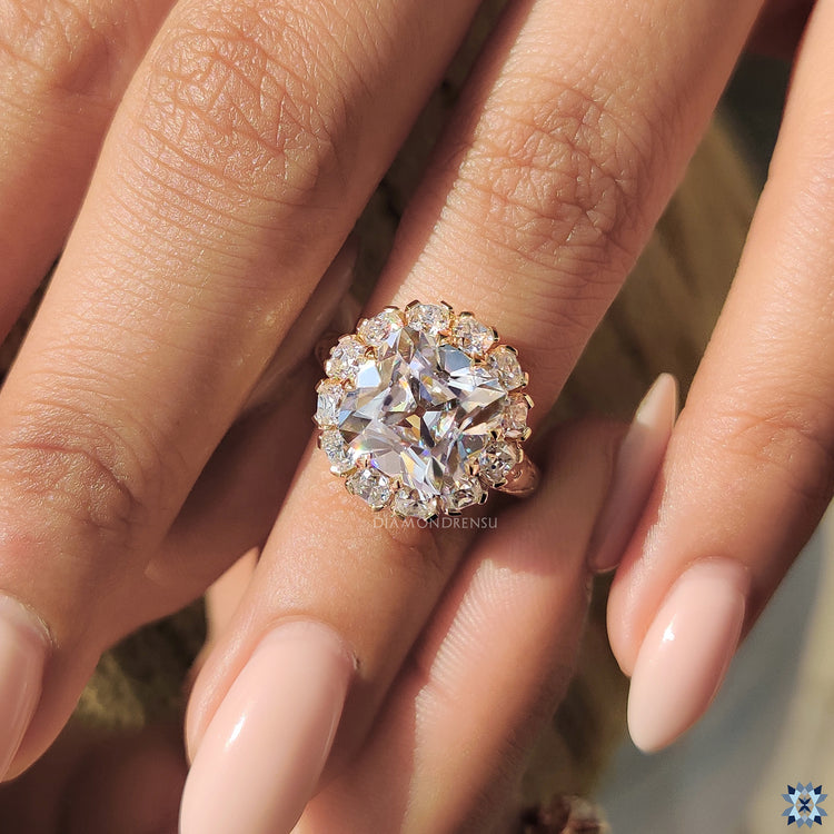 Yellow gold ring with round cut moissanite under halo.
