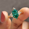 3 stone engagement ring with green Dutch marquise moissanite and triangle sides.
