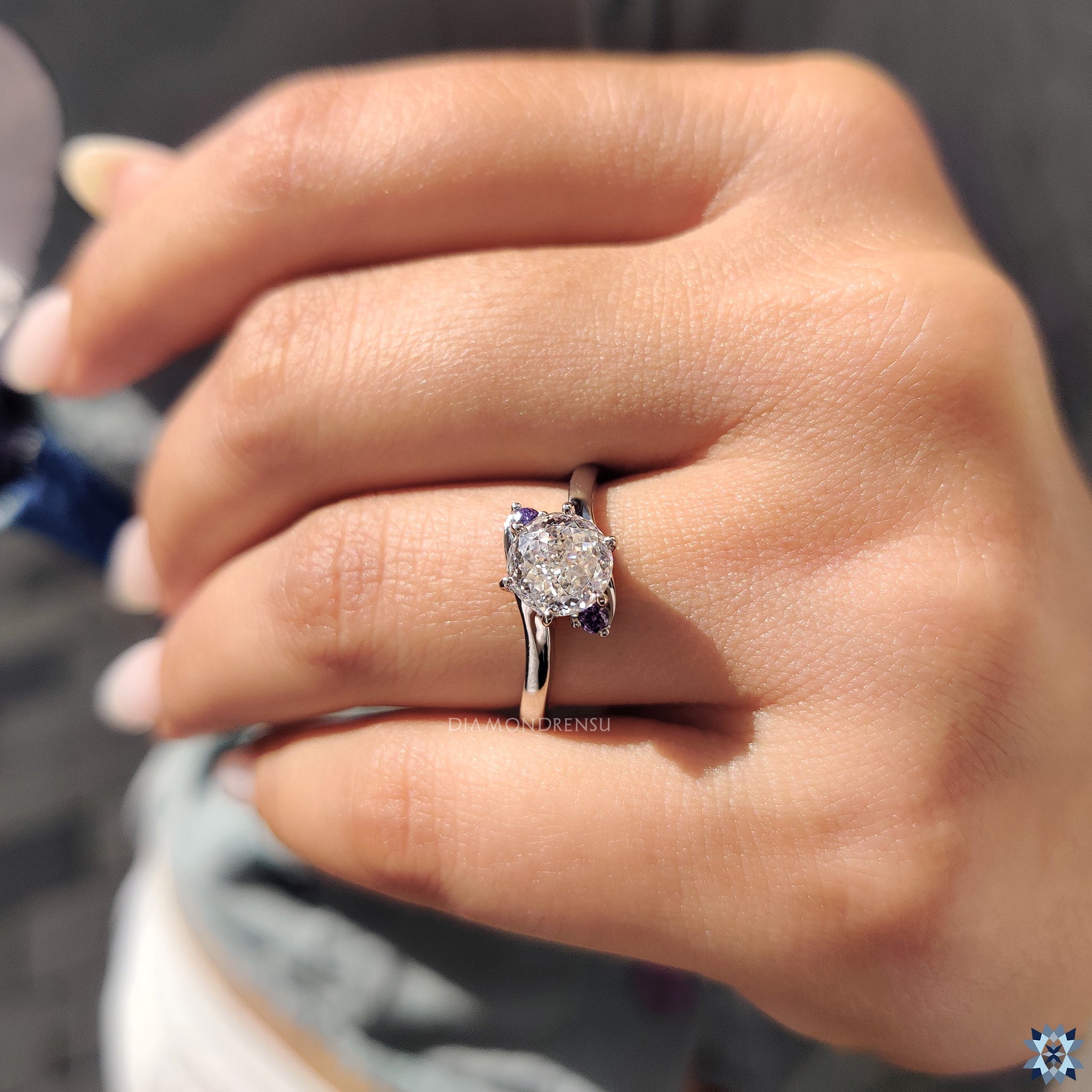 Moissanite engagement ring with round rose cut side stones and bypass styling.
