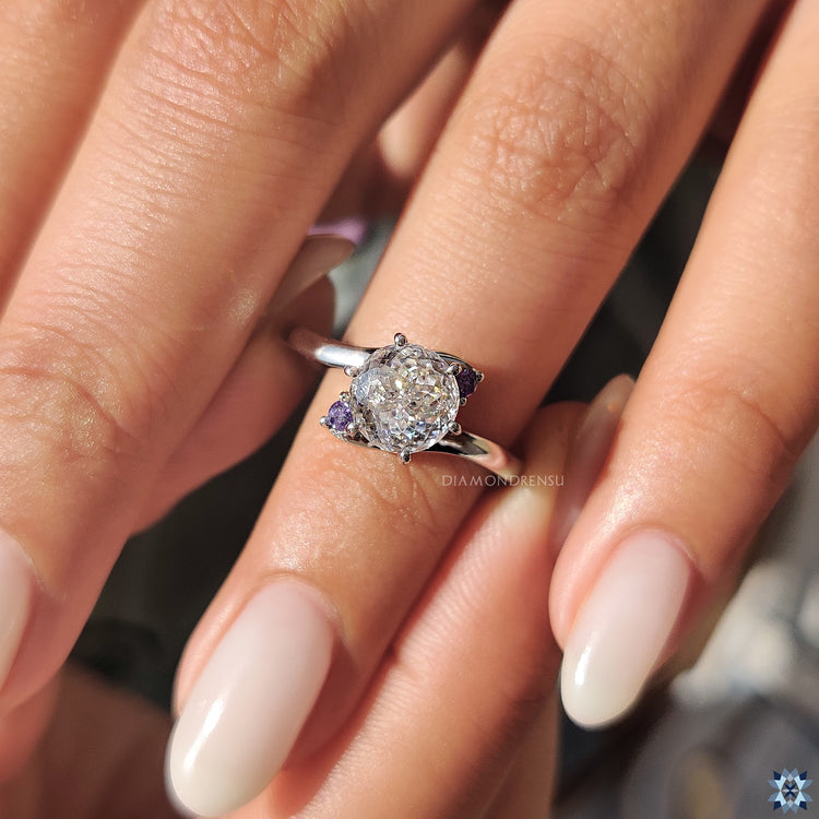 White gold ring with three stone layout and 6 prong moissanite centre.
