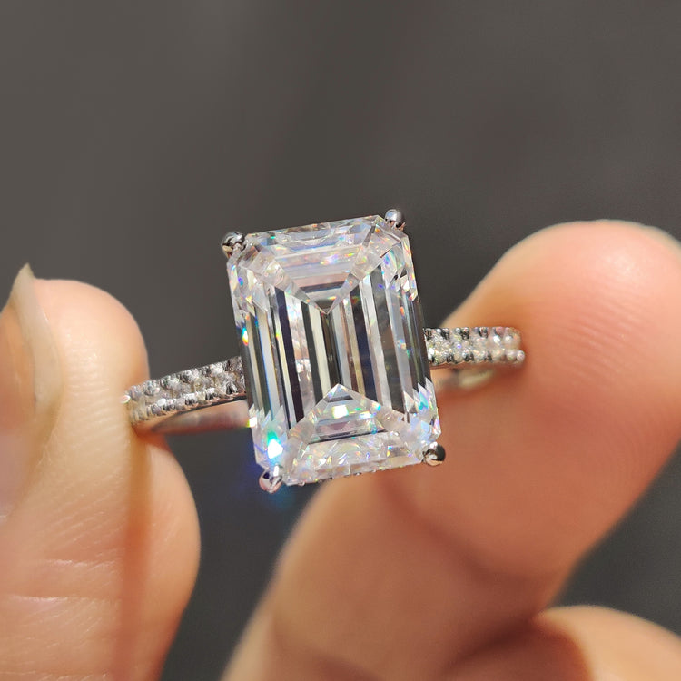Gold emerald cut engagement ring with a hidden halo and pave band.
