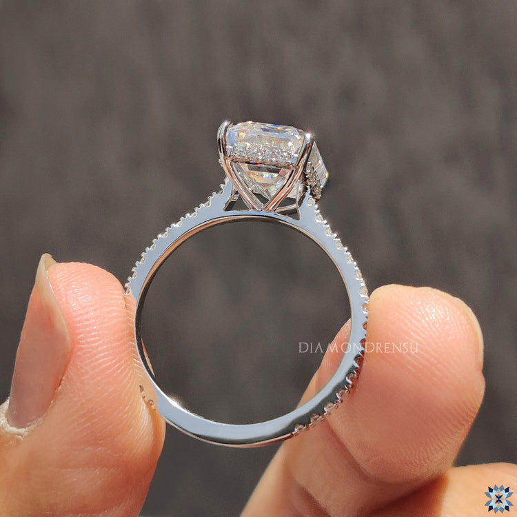 Round cut pave band crafted in white gold with an emerald cut stone.
