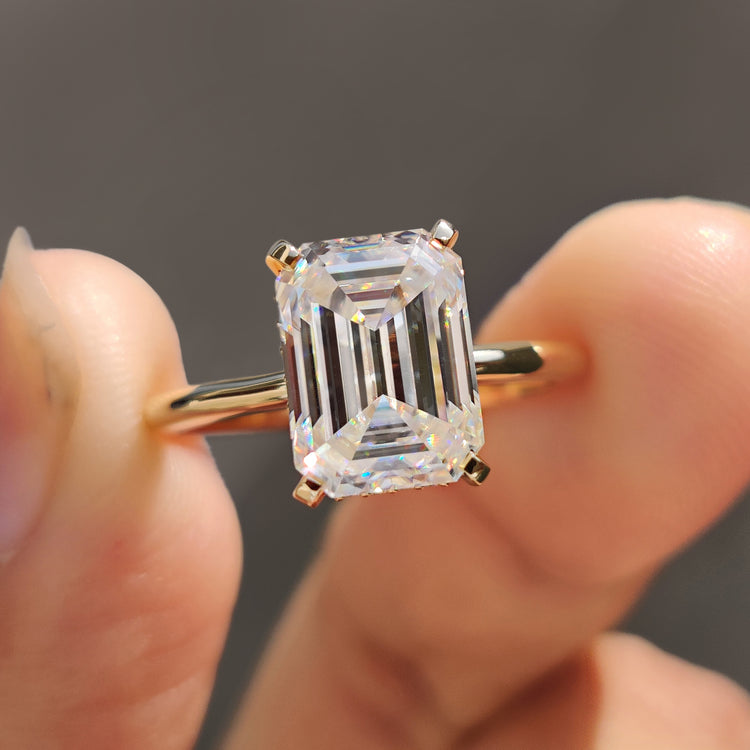 Emerald cut ring crafted in yellow gold with a round cut hidden halo.
