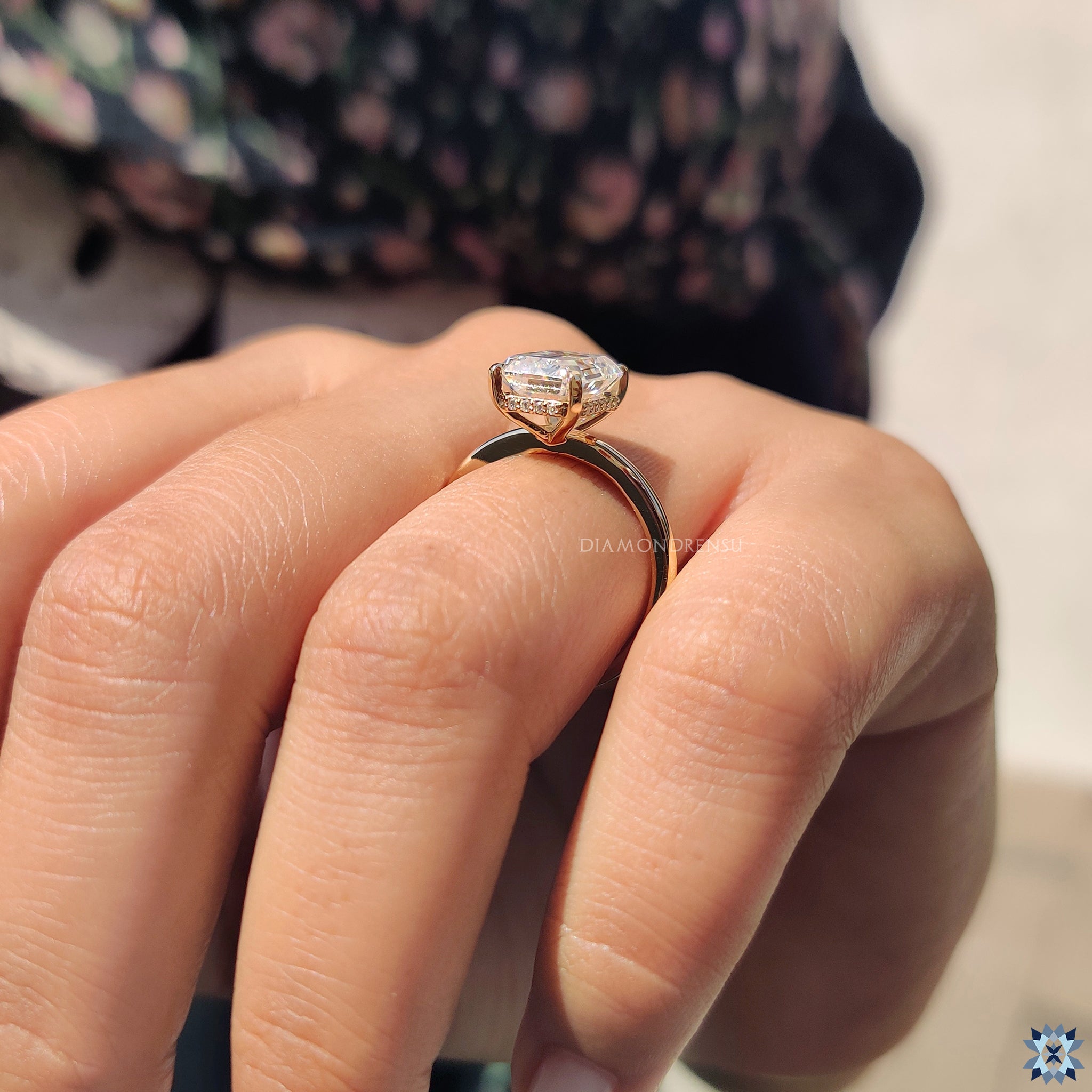 Handmade jewellery piece featuring a hidden halo around an emerald cut stone.
