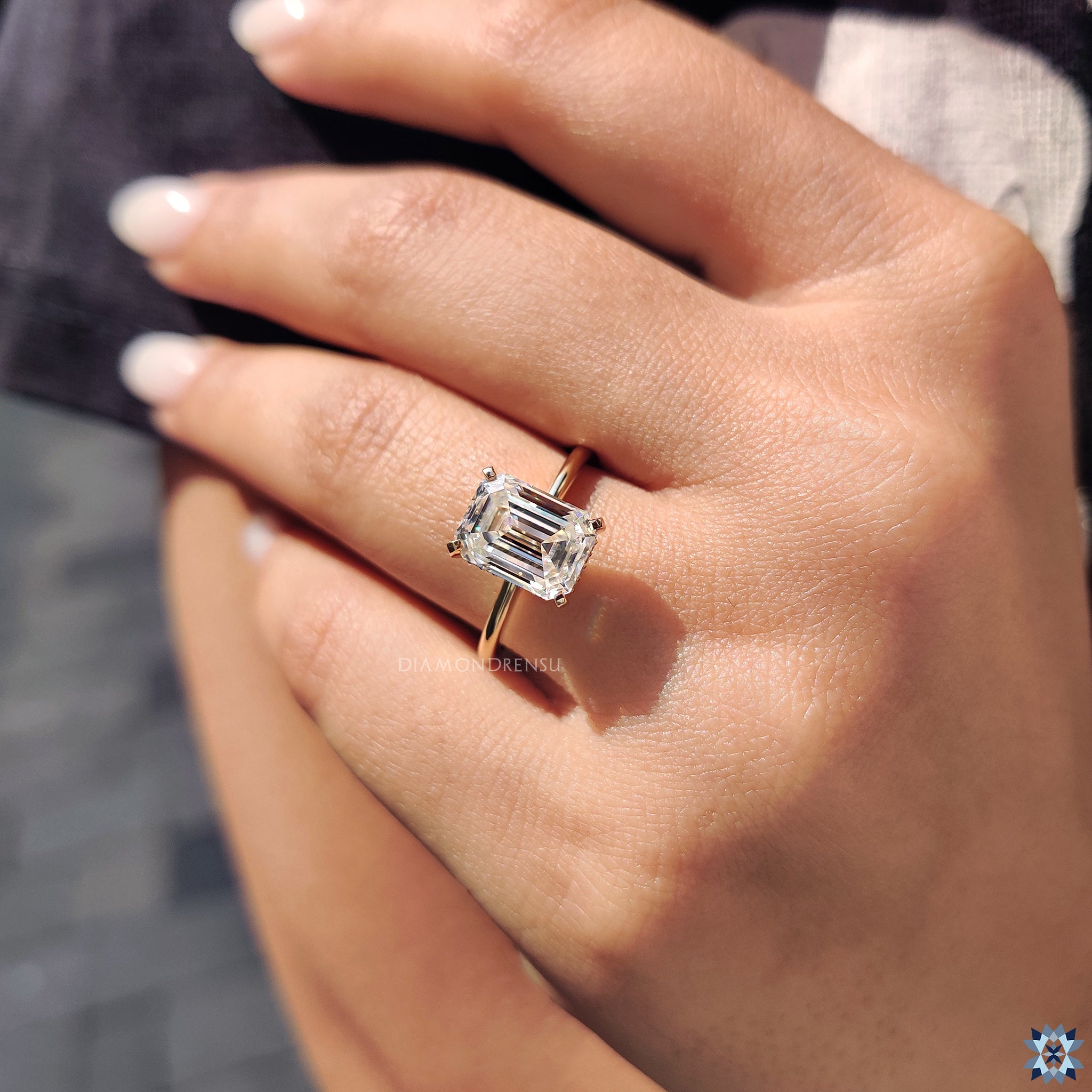 Emerald cut moissanite ring set in yellow gold with hidden halo sparkle.
