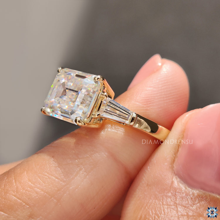 Buy engagement ring with East-West emerald cut moissanite in yellow gold.
