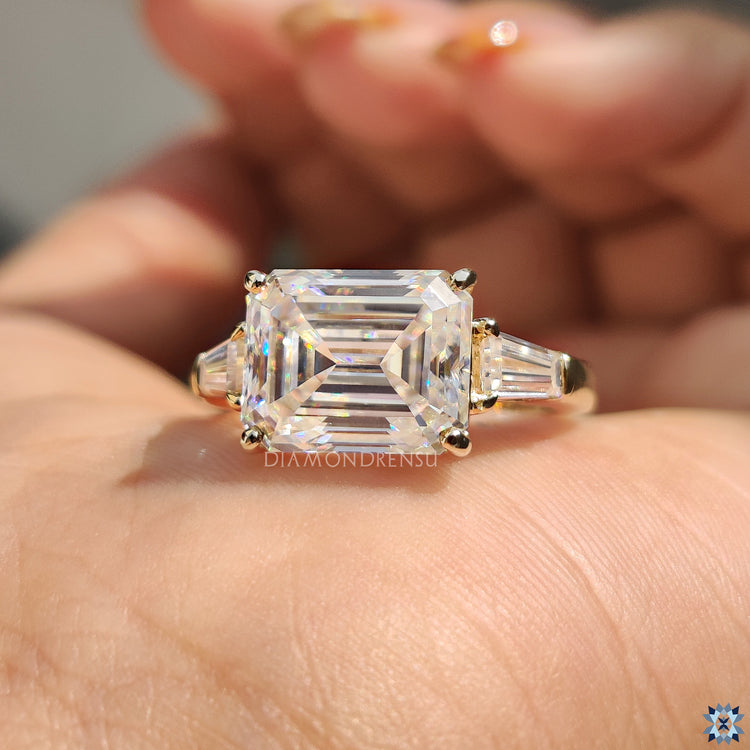Handmade jewellery with emerald cut centre and elegant round prong setting.
