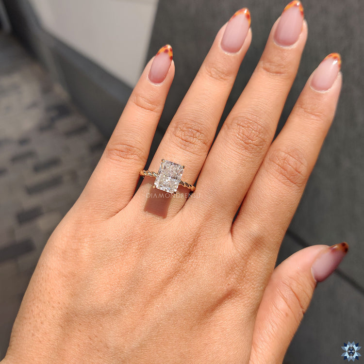 Elegant radiant cut ring with 4 claw prong in yellow gold.
