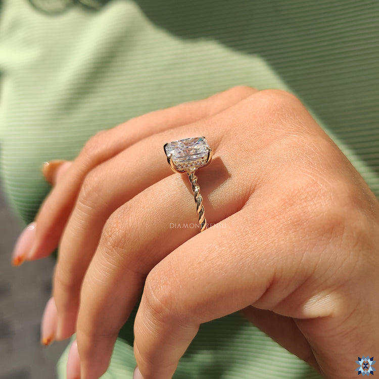 Hidden halo engagement ring featuring radiant centre and round cut halo.
