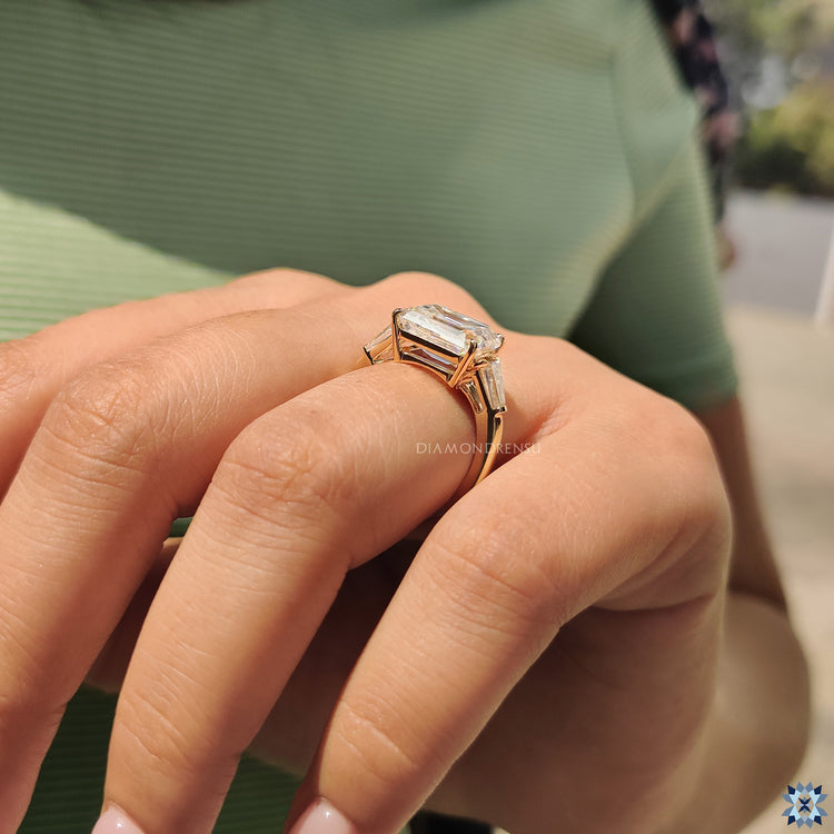 Diamondrensu UK engagement ring with emerald cut moissanite and baguettes.

